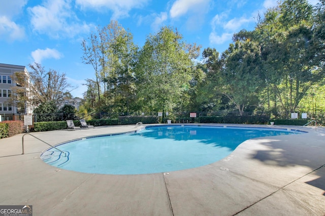 pool featuring fence and a patio