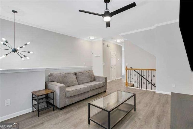 living room featuring crown molding, wood-type flooring, and ceiling fan with notable chandelier