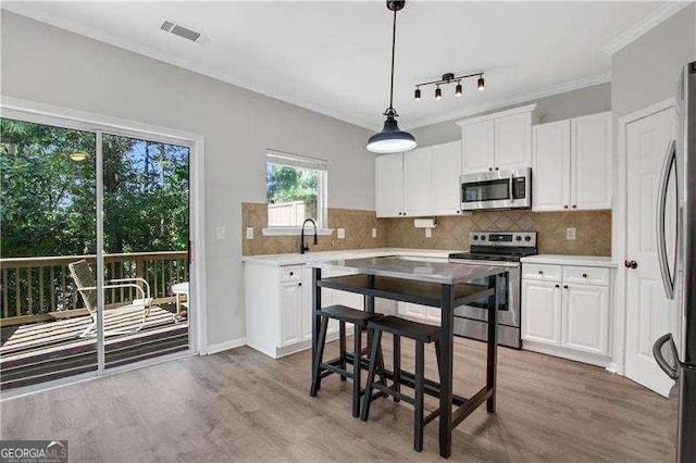 kitchen featuring hardwood / wood-style floors, stainless steel appliances, and white cabinetry