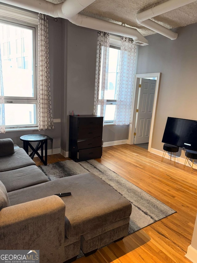 living room with hardwood / wood-style floors and a textured ceiling