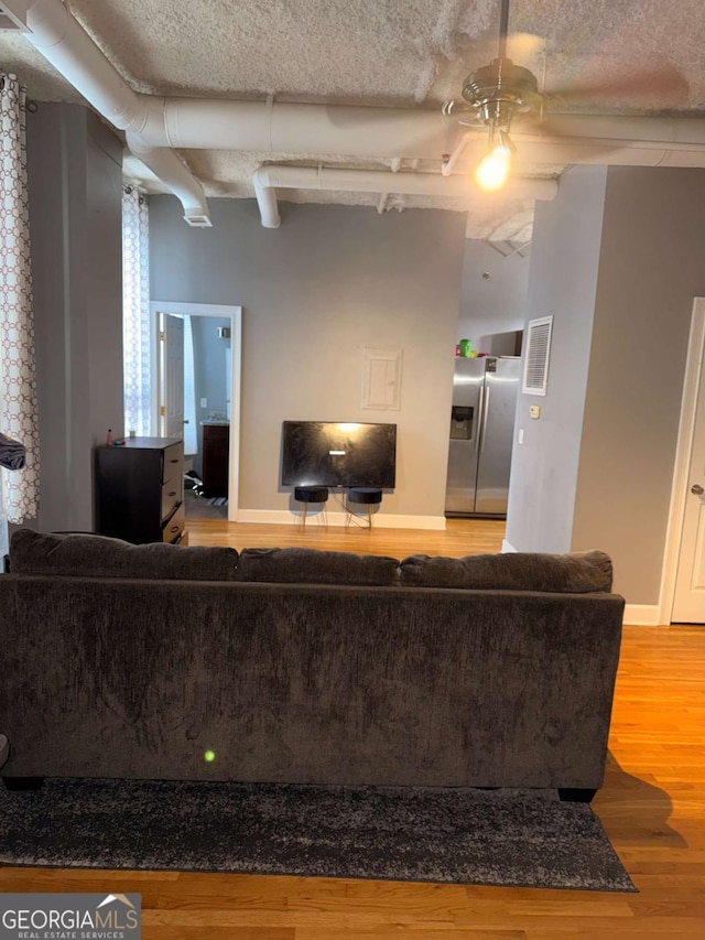 living room with a textured ceiling and hardwood / wood-style flooring