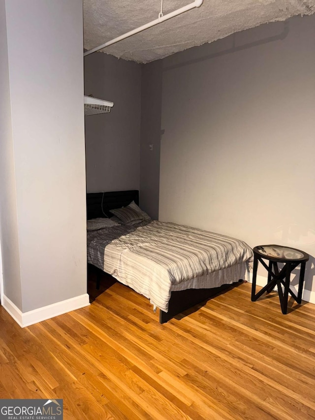 bedroom with wood-type flooring and a textured ceiling