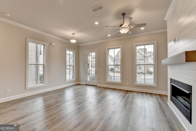 unfurnished living room with hardwood / wood-style flooring, ceiling fan, and crown molding