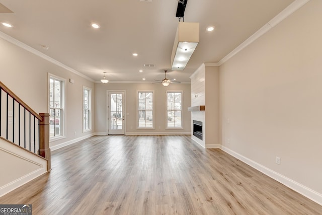 unfurnished living room with a fireplace, ceiling fan, light hardwood / wood-style flooring, and ornamental molding