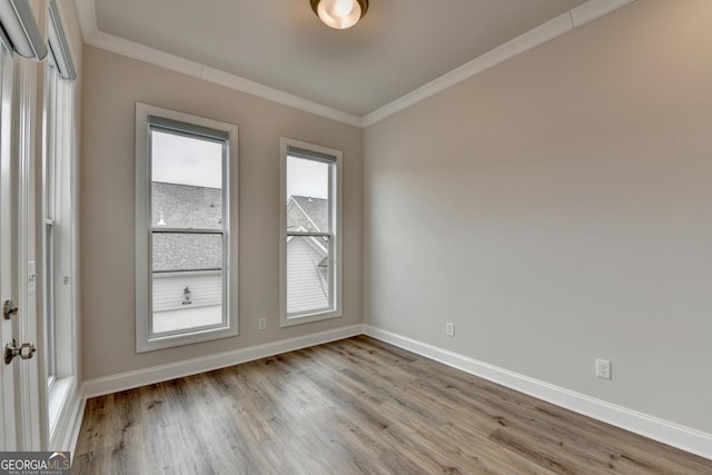 unfurnished room with crown molding and light wood-type flooring