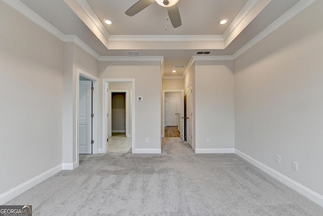 carpeted empty room featuring a raised ceiling, ceiling fan, and ornamental molding