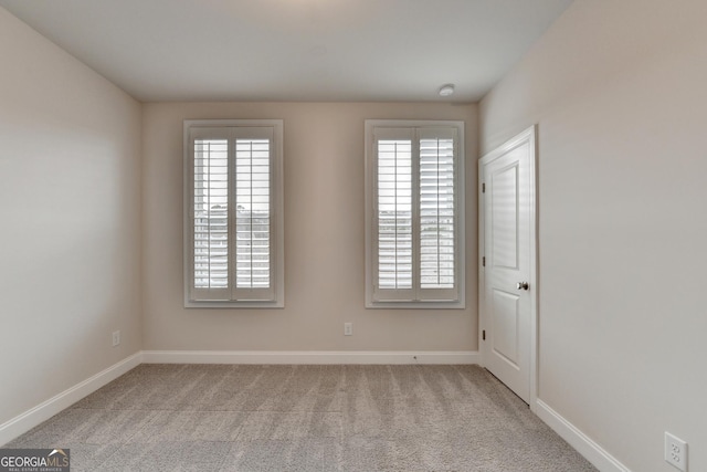 unfurnished room with light colored carpet and a healthy amount of sunlight