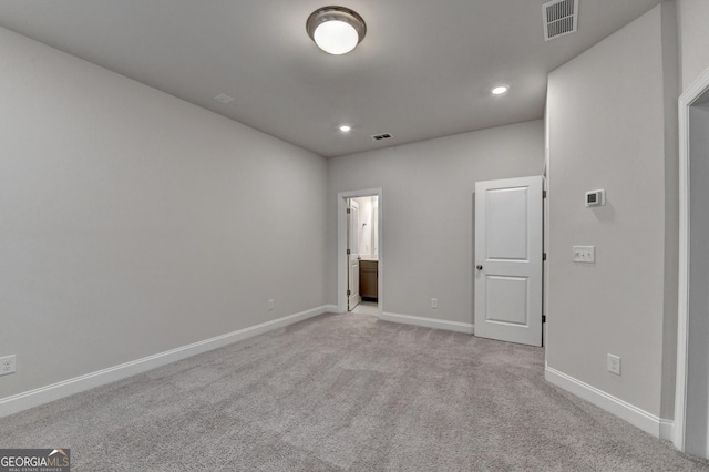 unfurnished bedroom with light carpet and ensuite bathroom