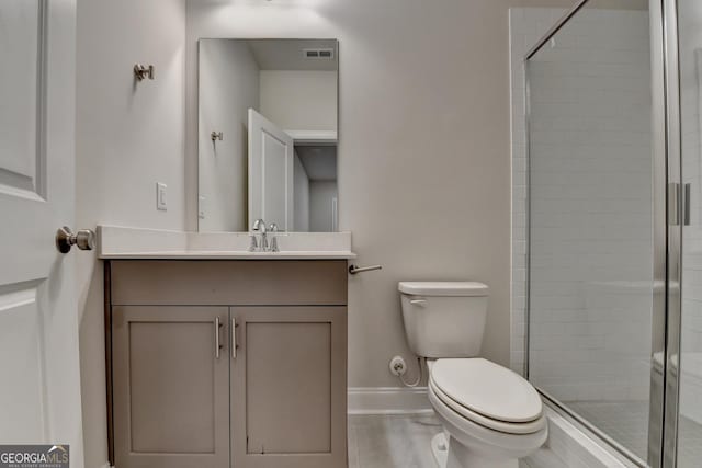 bathroom featuring vanity, toilet, and walk in shower