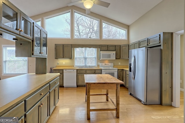 kitchen with ceiling fan, sink, high vaulted ceiling, light hardwood / wood-style floors, and white appliances