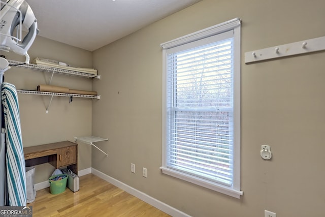 clothes washing area with light hardwood / wood-style floors