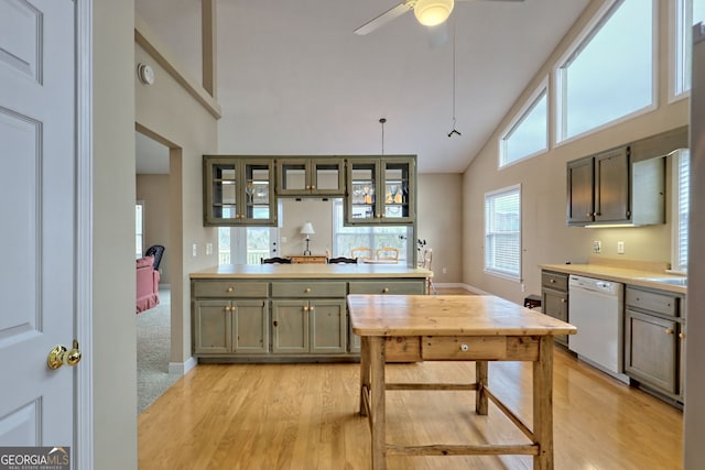 kitchen with white dishwasher, ceiling fan, decorative light fixtures, high vaulted ceiling, and light hardwood / wood-style floors