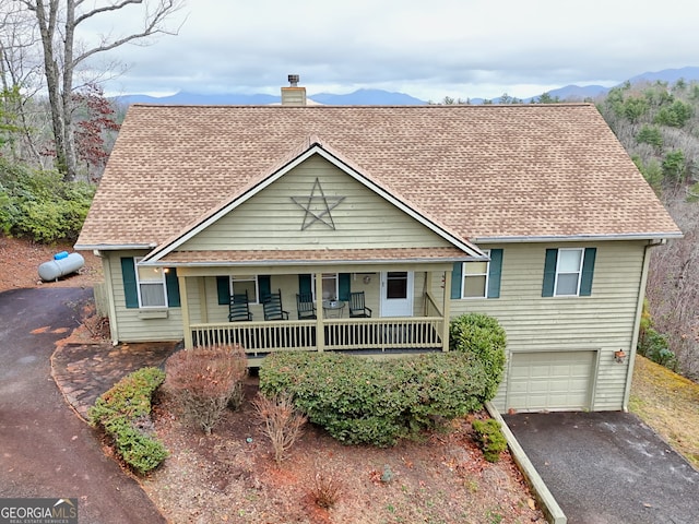 view of front of house featuring a mountain view, a porch, and a garage