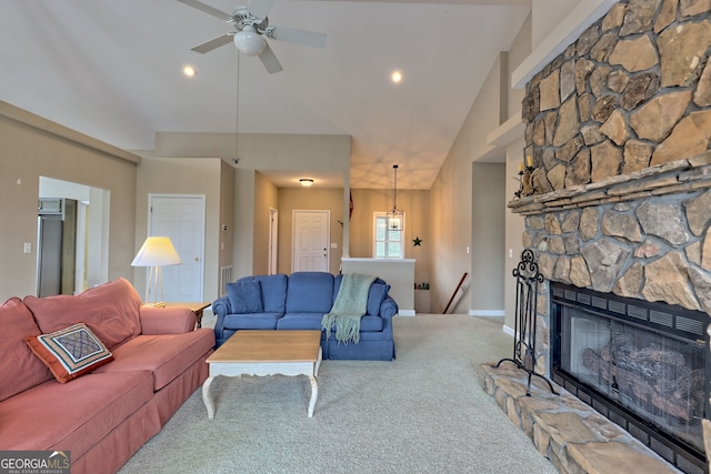 carpeted living room featuring a stone fireplace, ceiling fan, and lofted ceiling