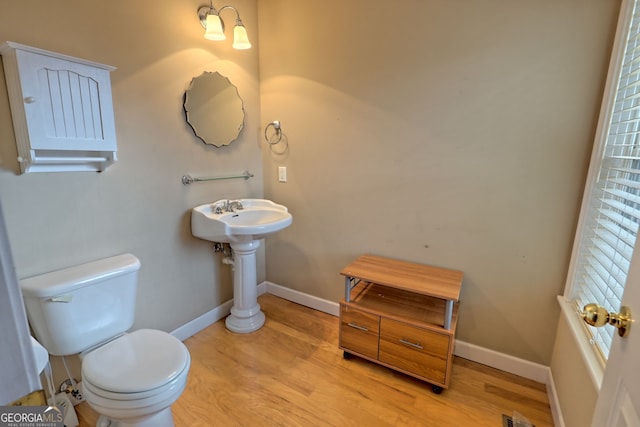 bathroom with toilet and wood-type flooring