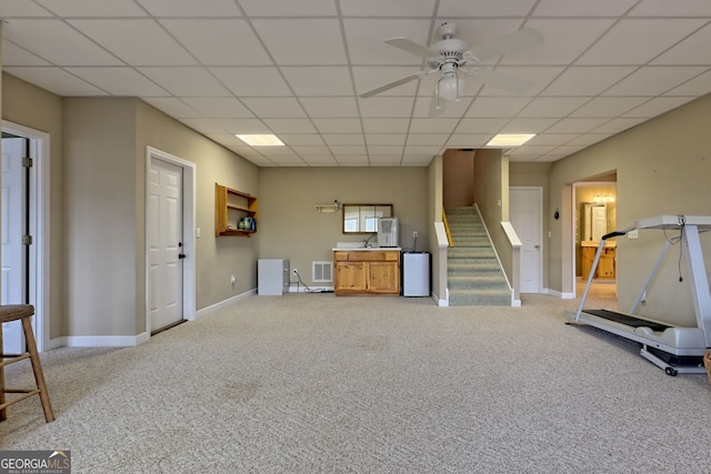 interior space with refrigerator, light colored carpet, and a drop ceiling