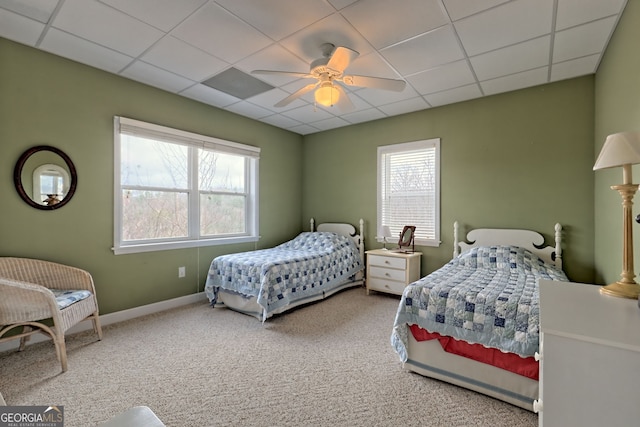 carpeted bedroom with ceiling fan and a drop ceiling