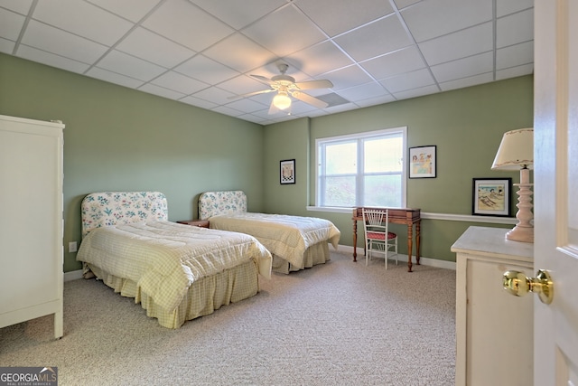 carpeted bedroom with a drop ceiling and ceiling fan