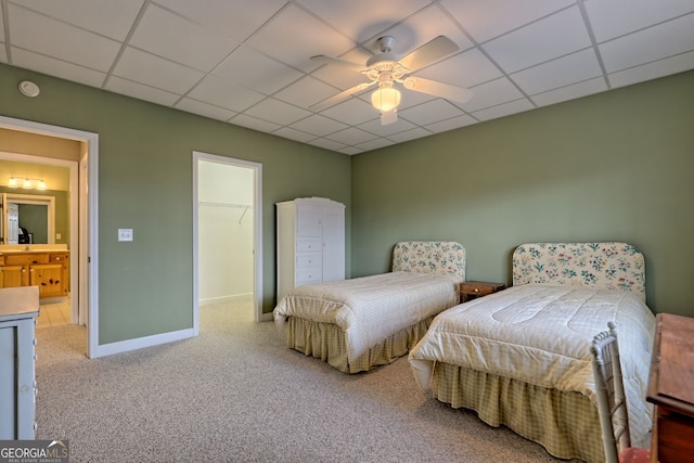 carpeted bedroom featuring ceiling fan, a closet, a spacious closet, and a drop ceiling