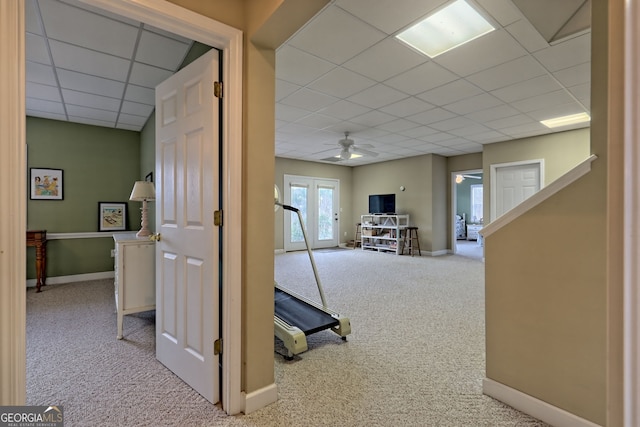 hall featuring light carpet, french doors, and a drop ceiling