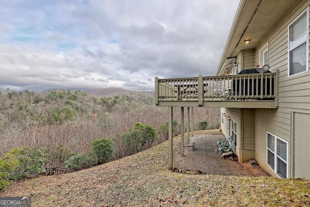 view of yard with a deck with mountain view