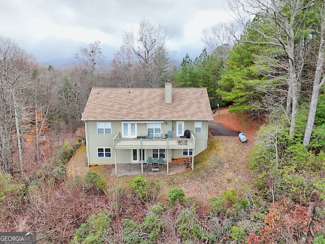 rear view of property featuring a patio and a wooden deck