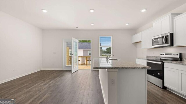 kitchen with dark hardwood / wood-style flooring, a center island with sink, white cabinets, and appliances with stainless steel finishes