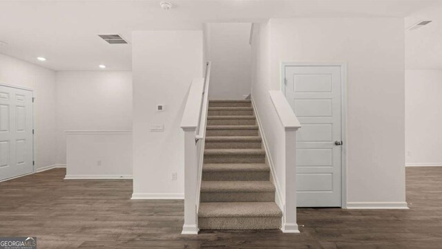 stairs featuring hardwood / wood-style floors