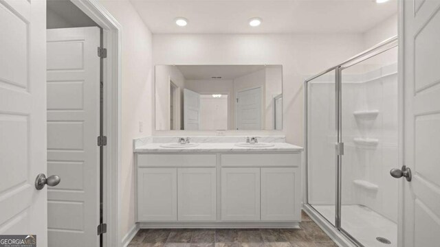 bathroom with hardwood / wood-style floors, vanity, and walk in shower