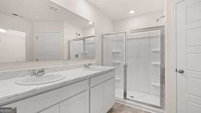 bathroom featuring tile patterned flooring, vanity, and a shower with shower door