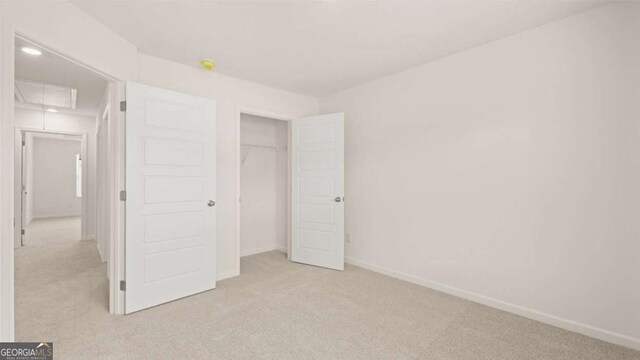 unfurnished bedroom with a closet and light colored carpet