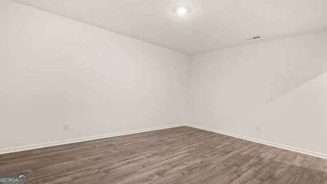 unfurnished room with dark hardwood / wood-style flooring