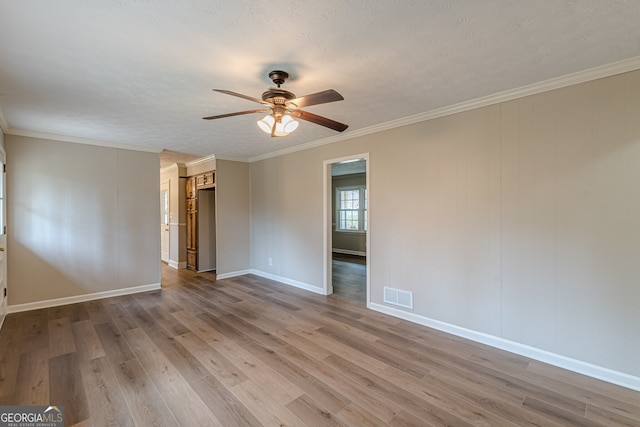 empty room with crown molding, wood-type flooring, a textured ceiling, and ceiling fan