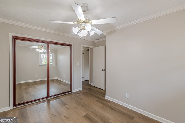 4485 Canary Ct, Lithia Springs, GA 30122 - unfurnished bedroom featuring baseboards, wood finished floors, crown molding, a closet, and a ceiling fan