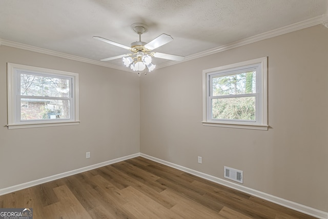 empty room with hardwood / wood-style flooring, ornamental molding, a textured ceiling, and ceiling fan