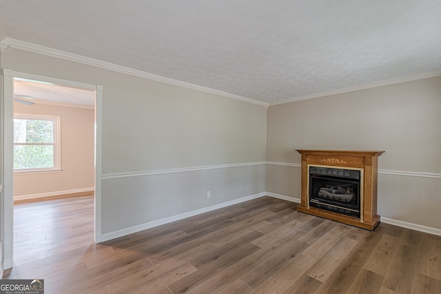 unfurnished living room with hardwood / wood-style flooring, ornamental molding, and a textured ceiling