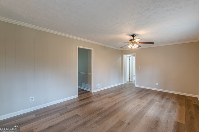 4485 Canary Ct, Lithia Springs, GA 30122 - unfurnished living room featuring wood finished floors, baseboards, a fireplace with raised hearth, a textured ceiling, and crown molding