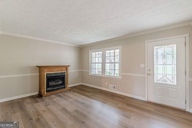 entryway featuring ornamental molding, a textured ceiling, and light hardwood / wood-style flooring