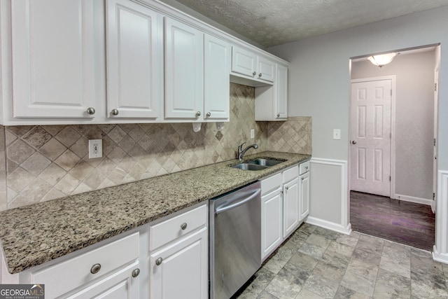 kitchen featuring decorative backsplash, white cabinets, light stone counters, sink, and dishwasher