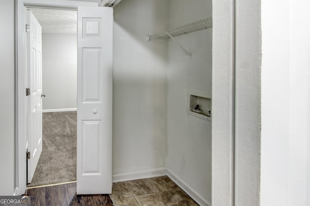 washroom with hookup for a washing machine, a textured ceiling, and dark carpet