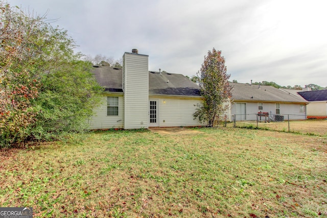 rear view of property with a lawn