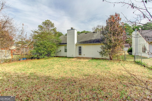 rear view of house featuring a yard