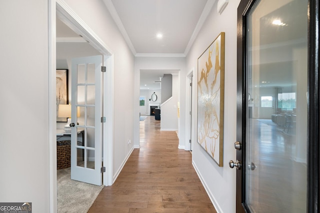 hall featuring ornamental molding, light hardwood / wood-style flooring, and french doors