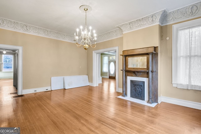 unfurnished living room featuring hardwood / wood-style floors and an inviting chandelier