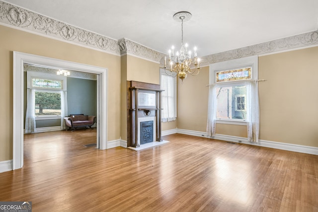 unfurnished living room with hardwood / wood-style flooring and an inviting chandelier