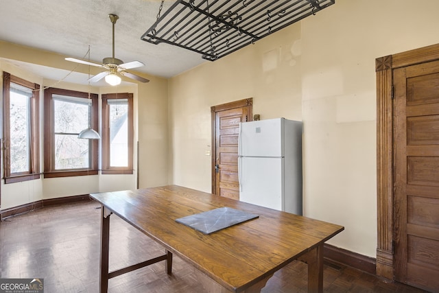 unfurnished dining area featuring a textured ceiling, dark hardwood / wood-style floors, and ceiling fan