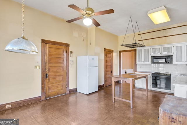 kitchen featuring a towering ceiling, white cabinetry, dark parquet floors, and white fridge