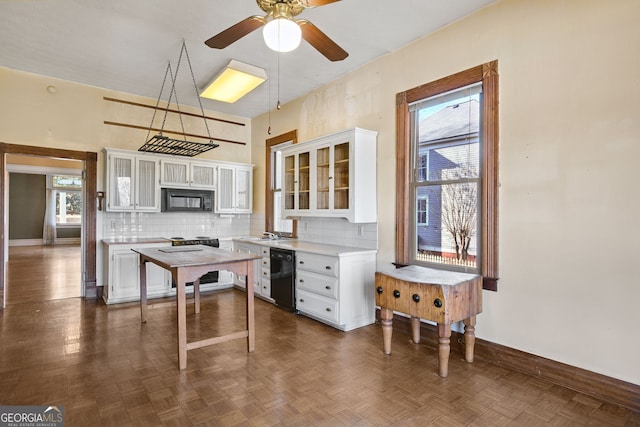 kitchen with black appliances, decorative light fixtures, white cabinets, and dark parquet floors