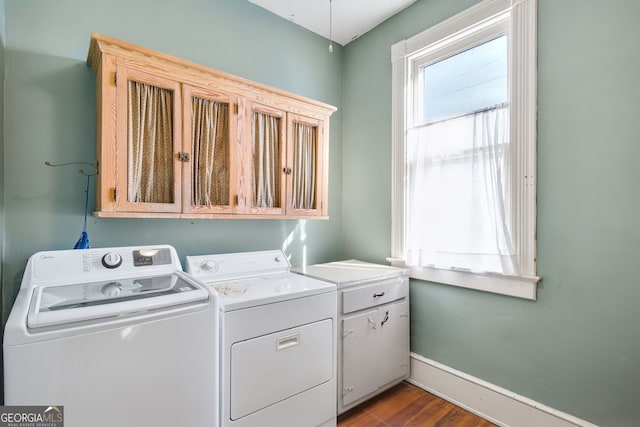 clothes washing area featuring light hardwood / wood-style floors, cabinets, and separate washer and dryer