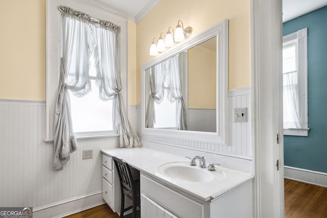 bathroom with vanity, hardwood / wood-style flooring, and crown molding